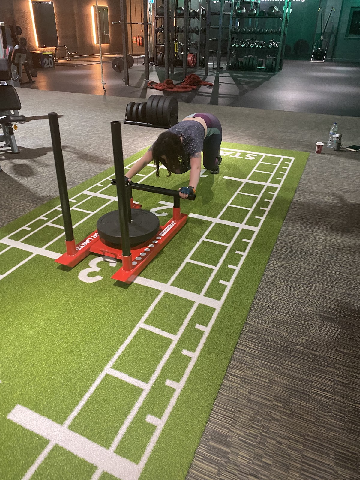 Sled push conditioning work on the turf track